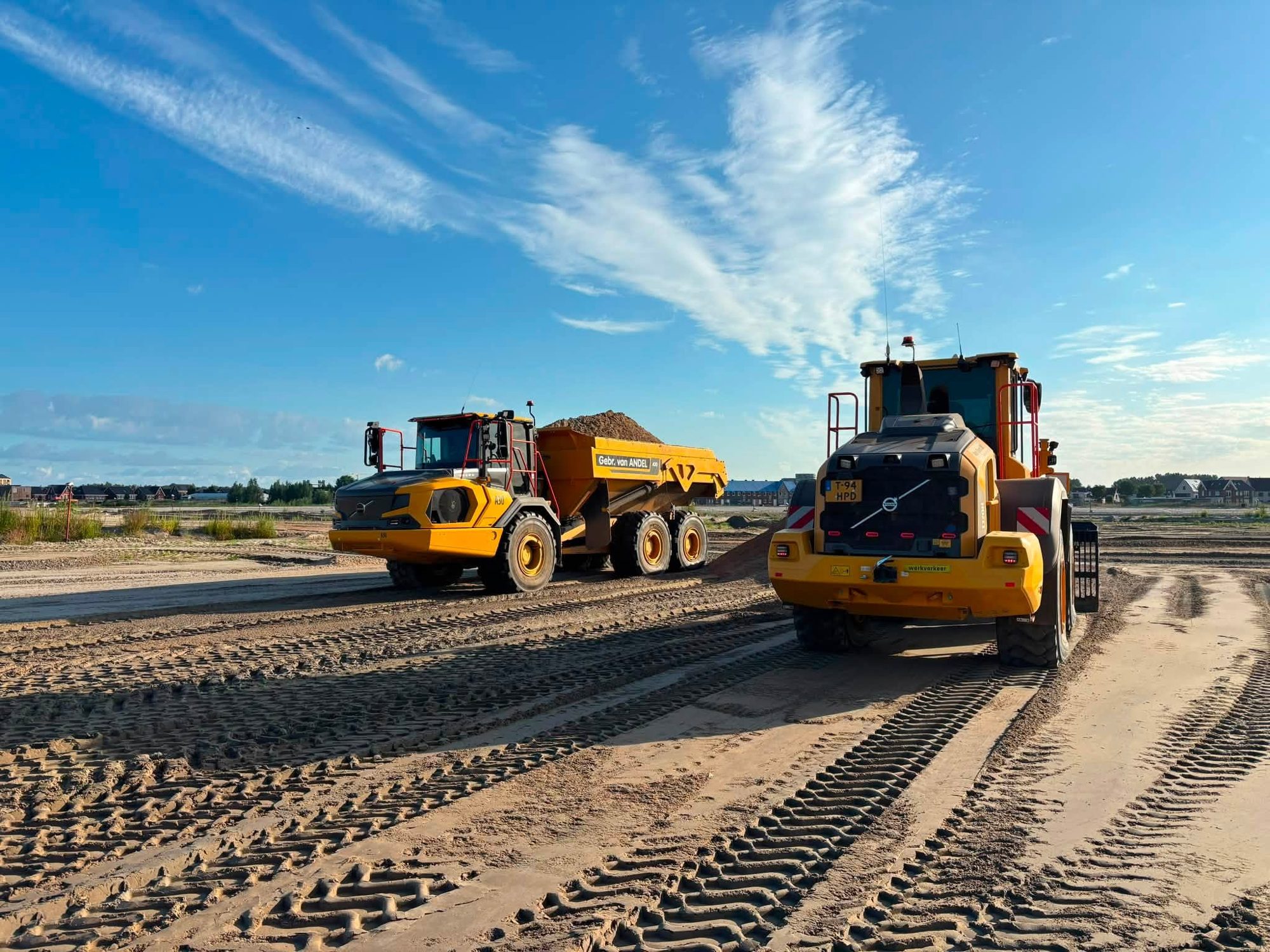 Geladen knikdumper en wiellader op het werk